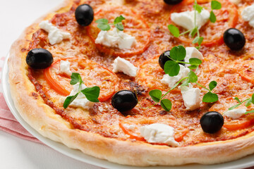 homemade pizza with tomatoes, olives and young cheese.