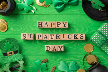 Top view photo of wooden cubes with words happy st patricks day party glasses leprechaun hat straws...