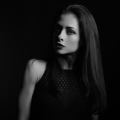 Naklejka premium Beautiful bright makeup woman with red lipstick with half face in shadow on dark red background with empty copy space. Closeup