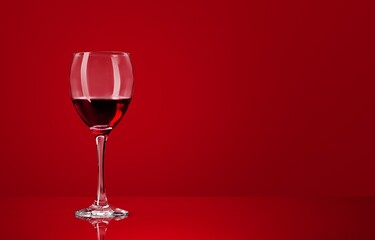 Obraz na płótnie Canvas Red wine glass over colored background on the desk