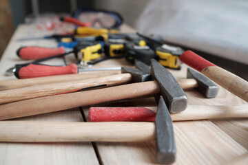 Close up of hammers and carpenters tools on woodworking table in workshop, copy space