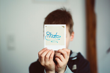 Young boy with instant photo Polaroid