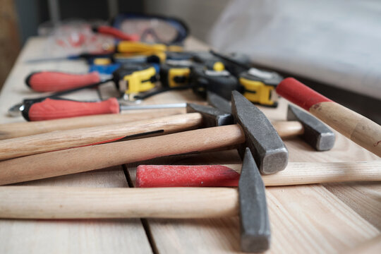 Close up of hammers and carpenters tools on woodworking table in workshop, copy space