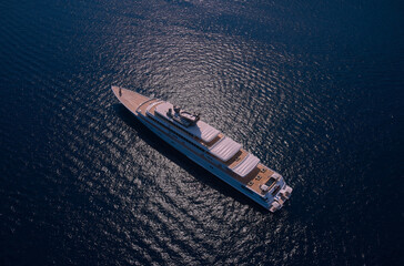 Big white super ship in the dark ocean aerial view. Big yacht for millionaires in the sea drone...