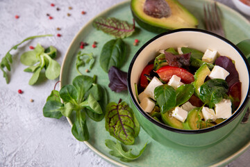 Salad of fresh vegetables, avocado, arugula, spinach with feta cheese. Healthy food rich in vitamins, fiber, antioxidants.