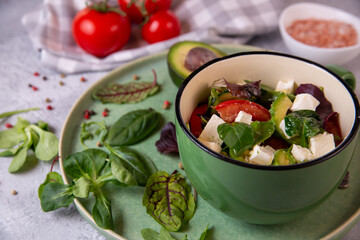 Salad of fresh vegetables, avocado, arugula, spinach with feta cheese. Healthy food rich in vitamins, fiber, antioxidants.