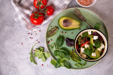 Salad of fresh vegetables, avocado, arugula, spinach with feta cheese. Healthy food rich in vitamins, fiber, antioxidants.
