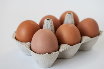 Closeup of fresh six brown eggs in paper box