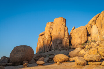Landscape with eroded orange granite rocks against clear blue sky in central Namibia.
