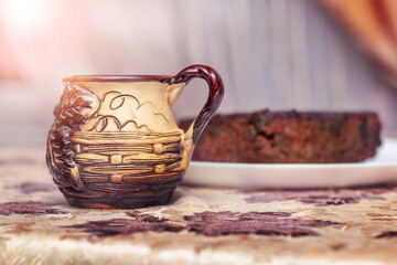Cup with tea and cake on the table by the window