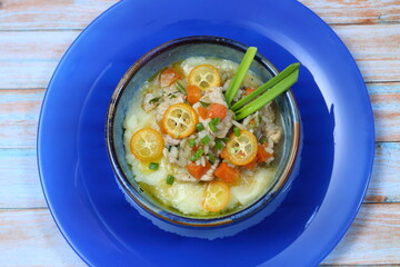Turkey stew with vegetables, kumquat and mashed potatoes on a blue background
