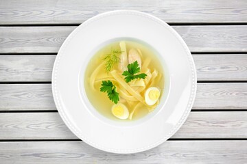 Tasty noodle soup with vegetables in bowl on the desk