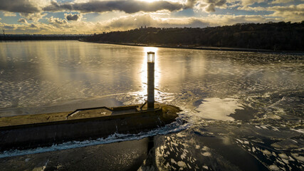 Aerial view of a pier with a lighthouse on a frozen lake
