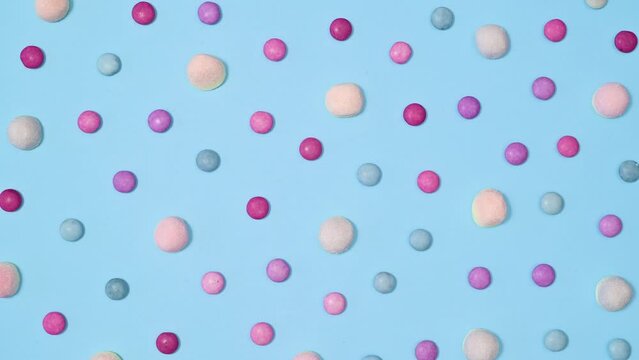 Creative pattern with pastel gummy candies move on bright cyan background. Stop motion flat lay concept