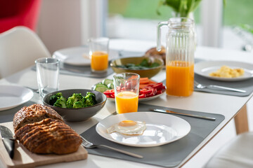 Breakfast closeup with eggs, wholegrain bread, fresh broccoli, and orange juice