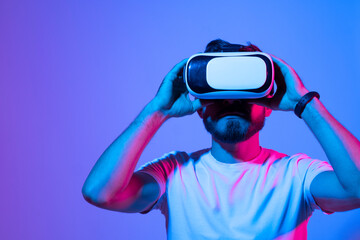 Closeup of young man developer wearing virtual reality goggles in modern studio workspace and working on a new perspective project.