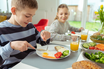 Teen brother and sister having healthy breakfast at home