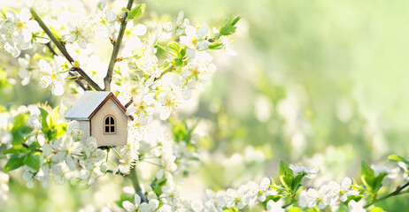 Fototapeta white toy house and cherry flowers, spring abstract natural background. concept of mortgage, construction, rental, family and property. eco-home. spring season. copy space obraz