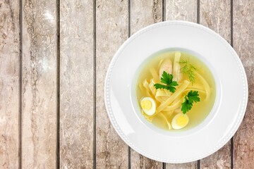 Tasty noodle soup with vegetables in bowl on the desk