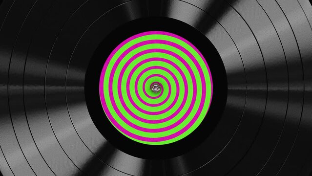Realistic seamless looping 3D animation of the green and pink hypnotic spiral label spinning vinyl record rendered in UHD as motion background