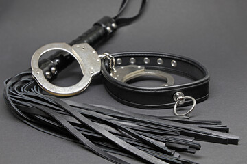 black leather whip, collar and hand cuffs