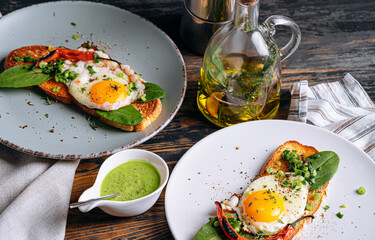 delicious and appetizing bruschetta with fried eggs and herbs for breakfast