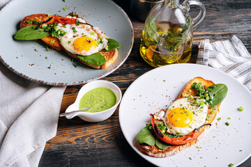 delicious and appetizing bruschetta with fried eggs and herbs for breakfast