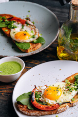 delicious and appetizing bruschetta with fried eggs and herbs for breakfast