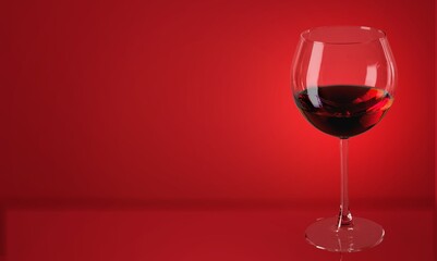 Red wine in the glass on the desk over red background