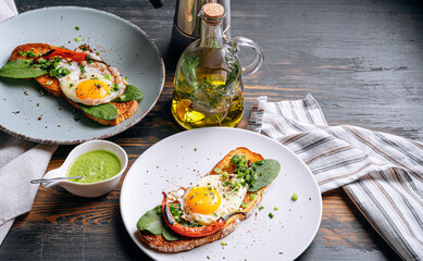 delicious and appetizing bruschetta with fried eggs and herbs for breakfast