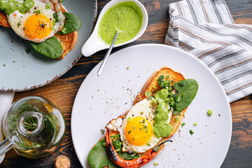 delicious and appetizing bruschetta with fried eggs and herbs for breakfast
