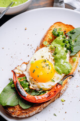 delicious and appetizing bruschetta with fried eggs and herbs for breakfast