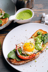 delicious and appetizing bruschetta with fried eggs and herbs for breakfast
