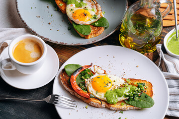 hearty and high-calorie breakfast. delicious and mouth-watering bruschetta with fried eggs and herbs for breakfast with a cup of aromatic coffee.