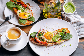 hearty and high-calorie breakfast. delicious and mouth-watering bruschetta with fried eggs and herbs for breakfast with a cup of aromatic coffee.