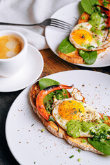 hearty and high-calorie breakfast. delicious and mouth-watering bruschetta with fried eggs and herbs for breakfast with a cup of aromatic coffee.