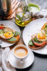 hearty and high-calorie breakfast. delicious and mouth-watering bruschetta with fried eggs and herbs for breakfast with a cup of aromatic coffee.