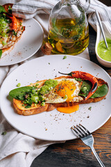 hearty and high-calorie breakfast. delicious and mouth-watering bruschetta with fried eggs and herbs for breakfast with a cup of aromatic coffee.
