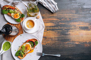 hearty and high-calorie breakfast. delicious and mouth-watering bruschetta with fried eggs and herbs for breakfast with a cup of aromatic coffee.