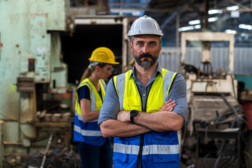 Engineers and skilled technicians are maintaining machinery. Engineers are working and repairing machines in industrial. worker while standing with arms crossed near factory.