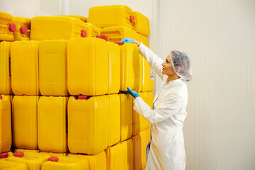 An oil refinery worker taking canes with oil.