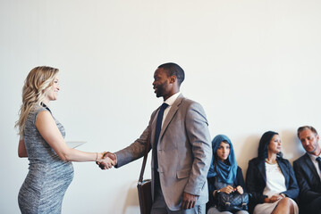 Are you ready for the interview. Shot of a cheerful young business receiving a handshake from a...