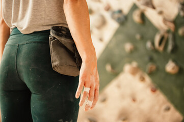 Climber wearing in climbing equipment. Practicing rock-climbing on a rock wall indoors. Xtreme...