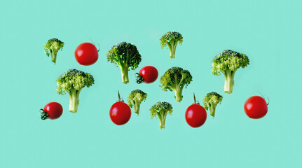 Creative vegetable background with flying broccoli and tomato on green background. The concept of healthy diet. Close-up