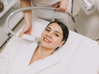 The cosmetologist makes the RF-lifting procedure for the client. Copy space. The concept of...
