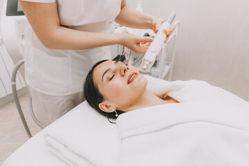The cosmetologist makes the RF-lifting procedure for the client. Copy space. The concept of...