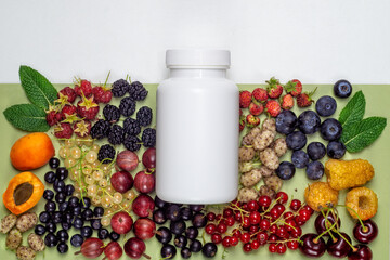White plastic jar with dietary supplements or vitamines and fresh berries