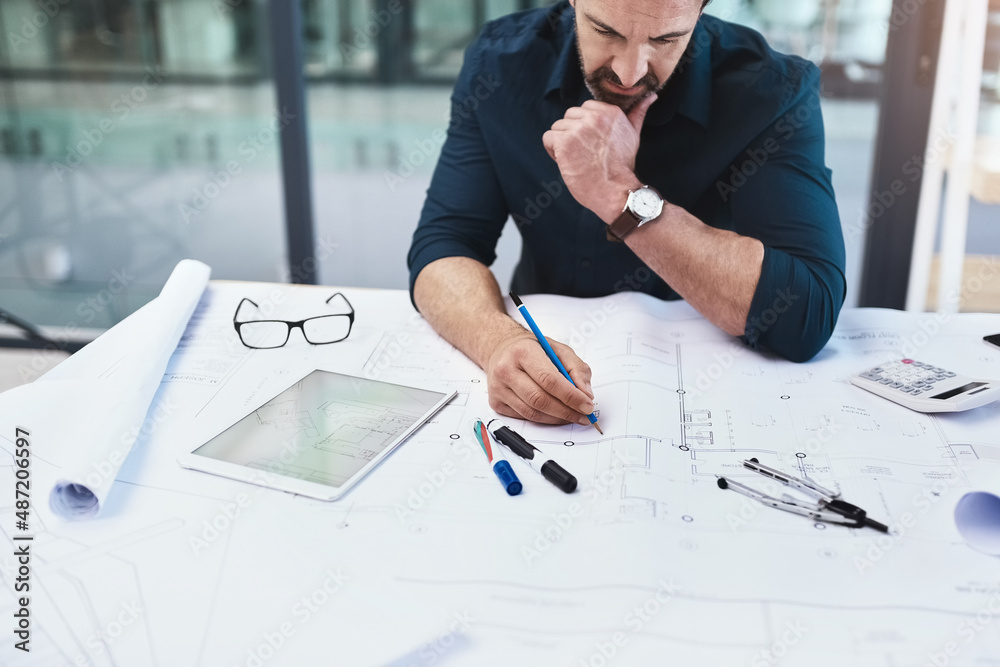 Poster Determining the necessary calculations to make the buildings work. Shot of a mature male architect working on a design.