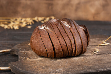 Homemade sourdough sliced bread loaf. Rye ears on the background. Close-up.