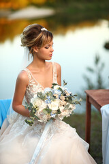 bride with a bouquet of flowers on the background of the river. High quality photo